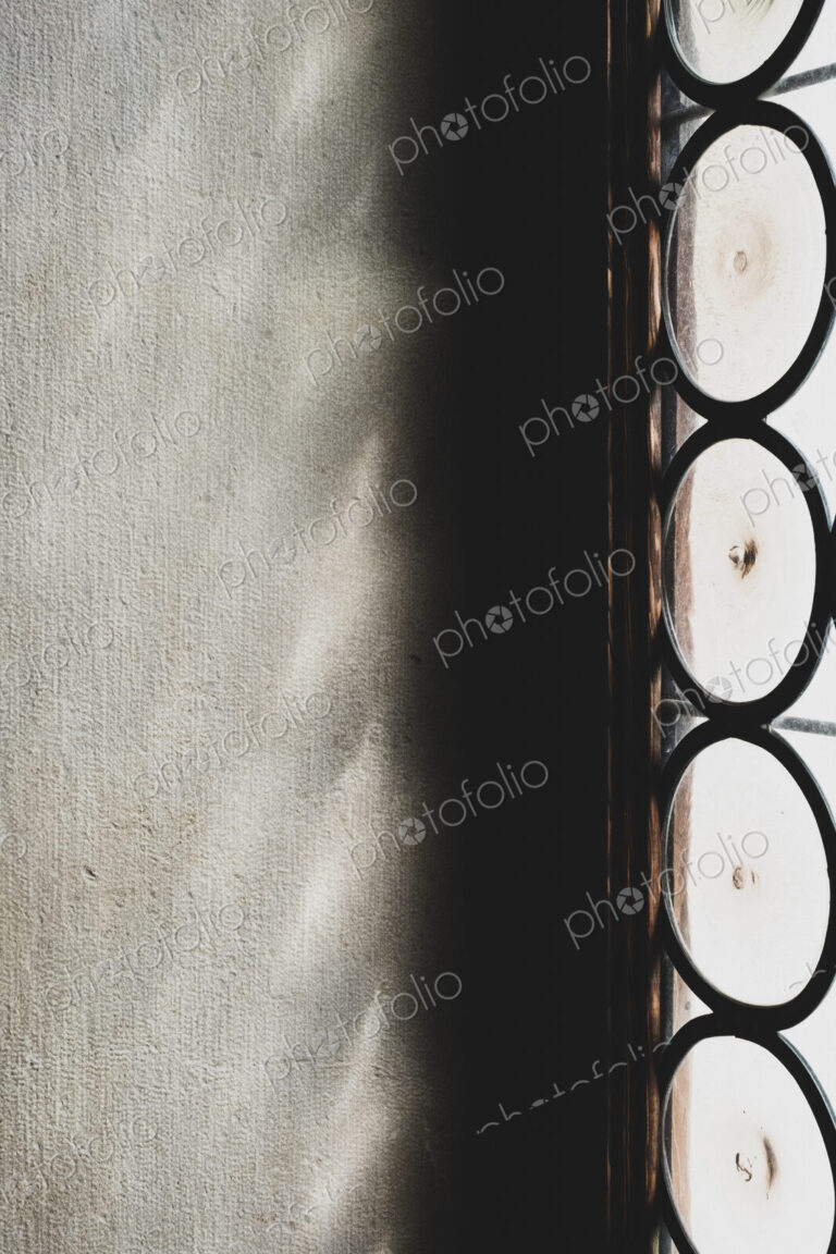 Close up of sunlight reflecting onto a wall through a leaded glass window.