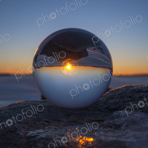 Close up of sunset horizon inverted in glass sphere