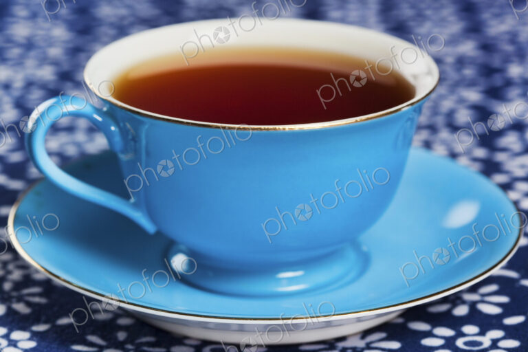Close up of tea in a blue porcelain teacup with matching saucer.