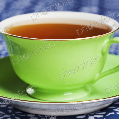 Close up of tea in a green porcelain teacup with matching saucer. Close up of tea in a green porcelain teacup with matching saucer.