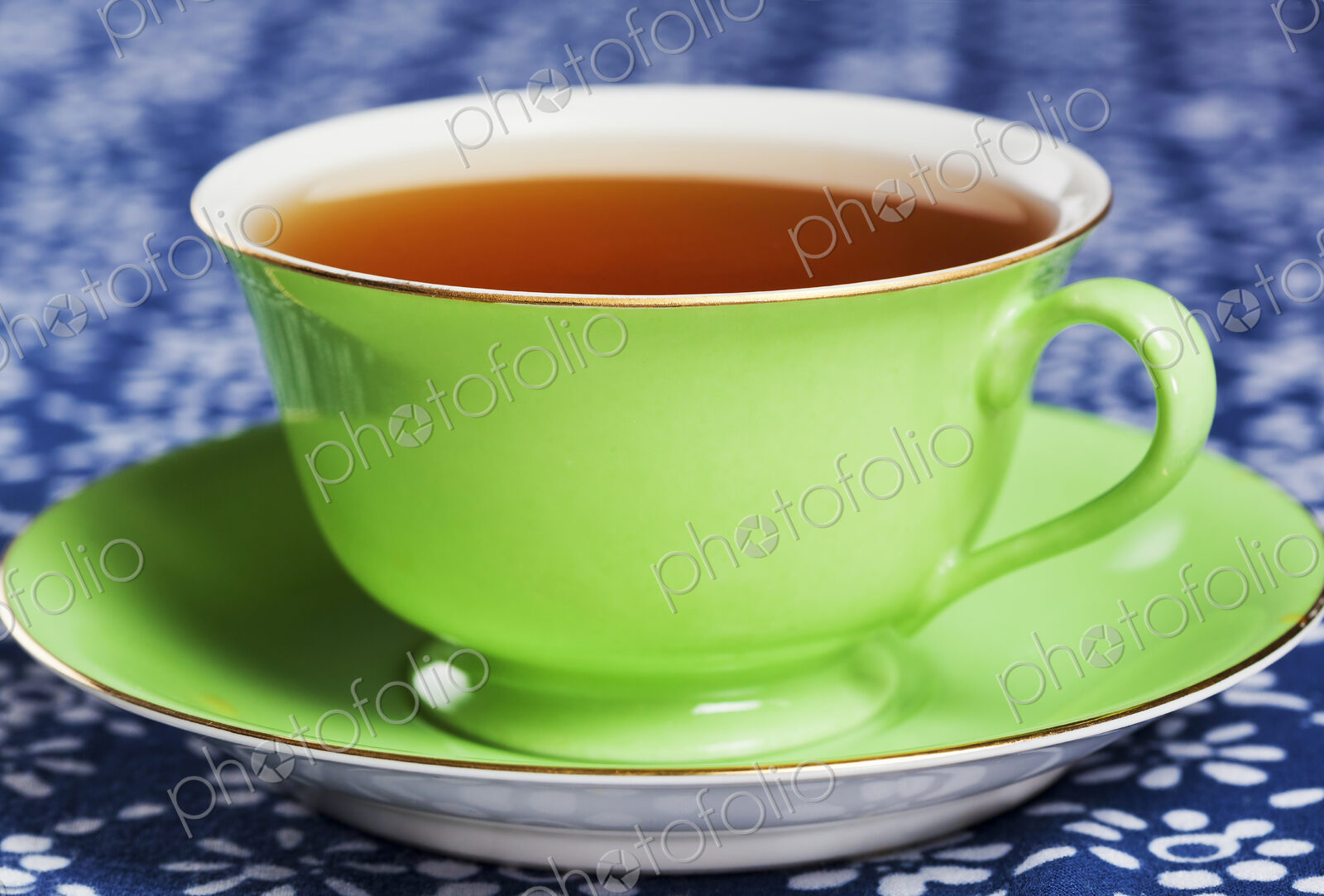 Close up of tea in a green porcelain teacup with matching saucer.