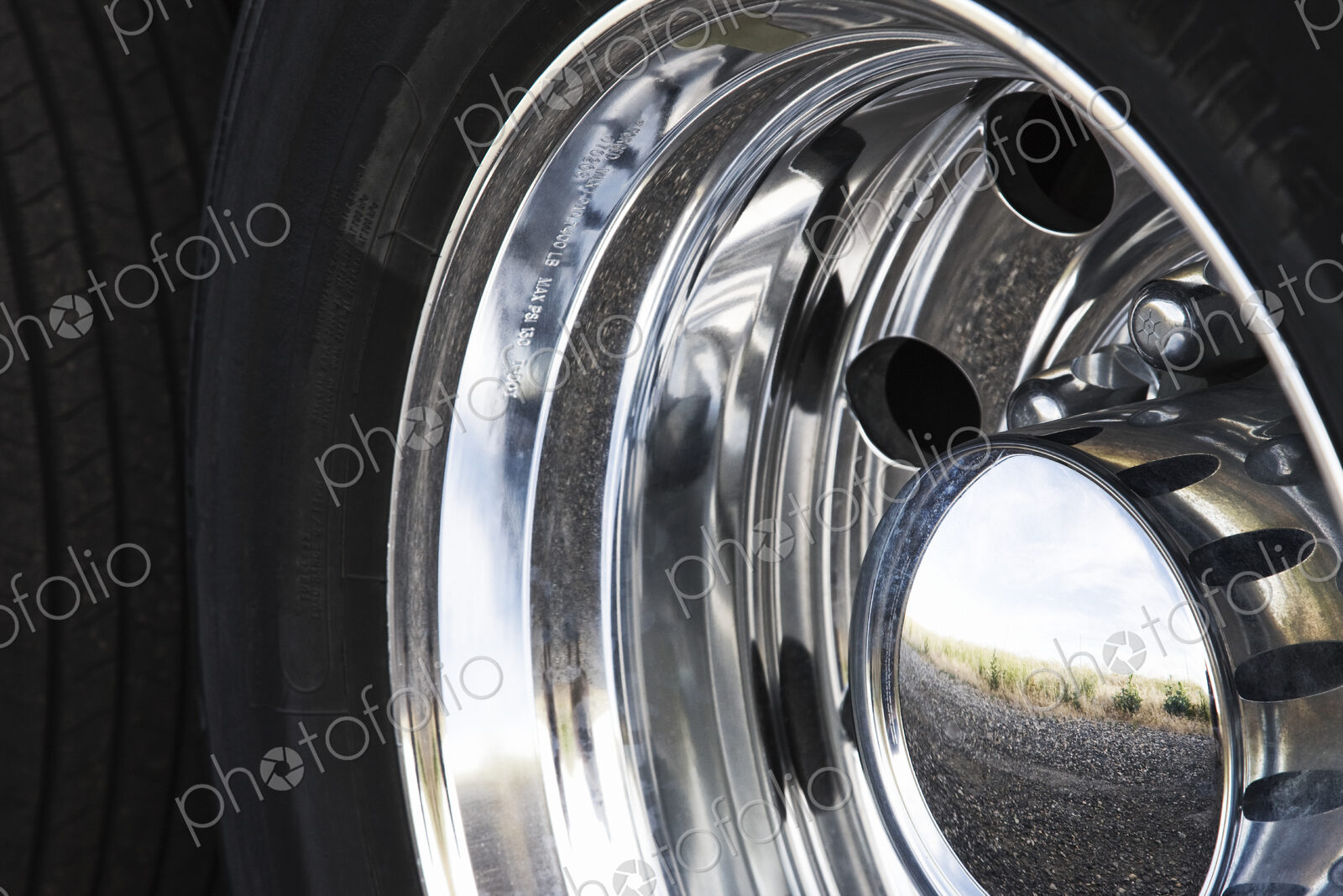 Close up of the chrome hub cap on a commercial truck tire.