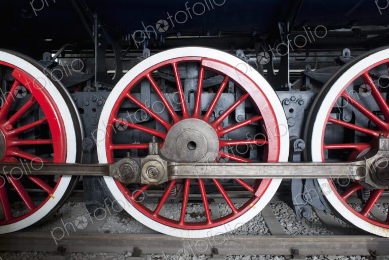 Close up of the rows of steel wheels of a locomotive steam train.