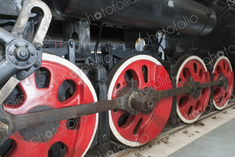 Close up of the rows of steel wheels of a locomotive steam train.