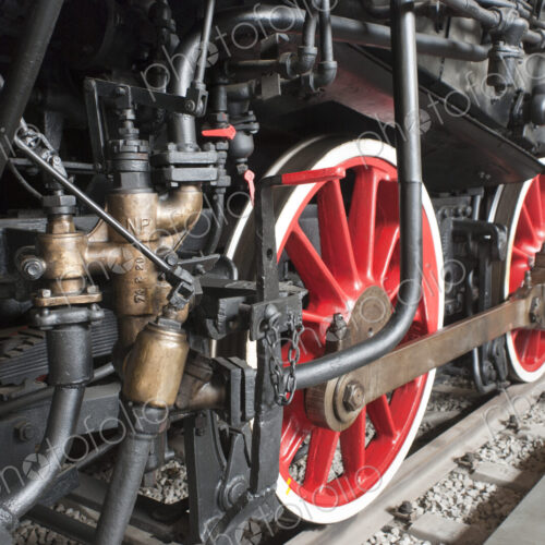 Close up of the rows of steel wheels of a locomotive train on a railway track.