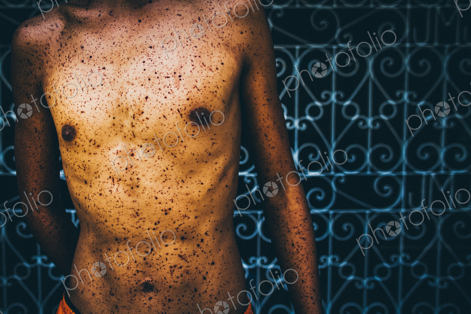 Close up of torso splattered with blood at a religious festival.