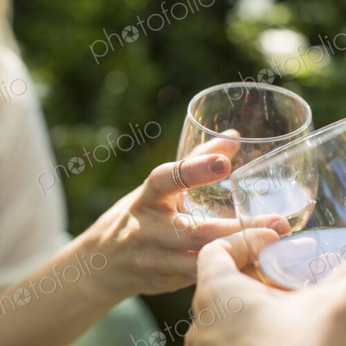 Close up of two people holding glasses with rose wine, toasting each other. Celebration. Close up of two people holding glasses with rose wine, toasting each other. Celebration.