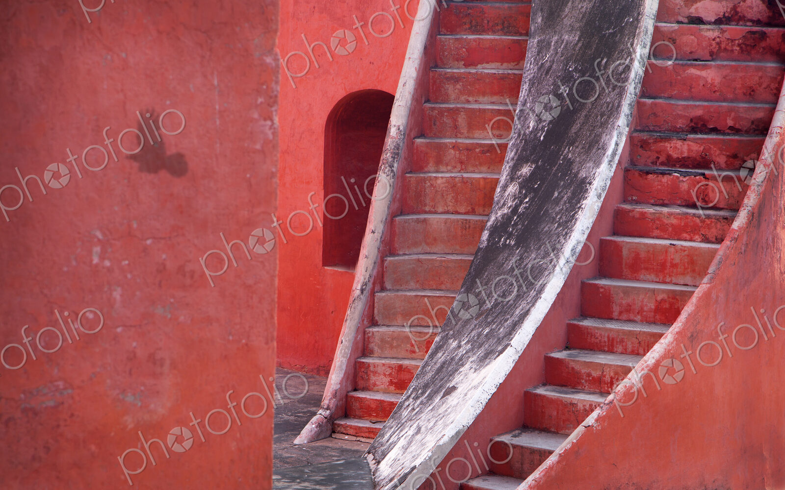 Close up of two steep stairway running parallel up a red building.