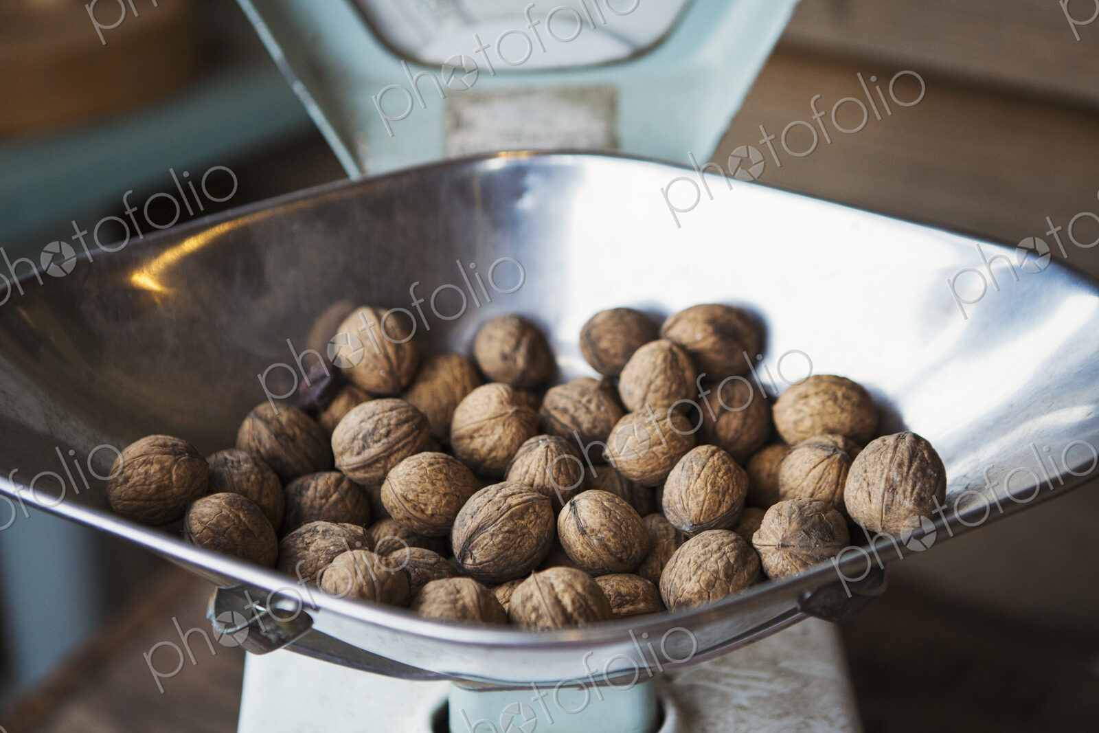 Close up of walnuts on metal weighing scales.