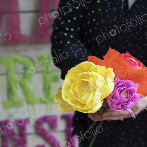 Close up of woman holding handcrafted fabric flowers.