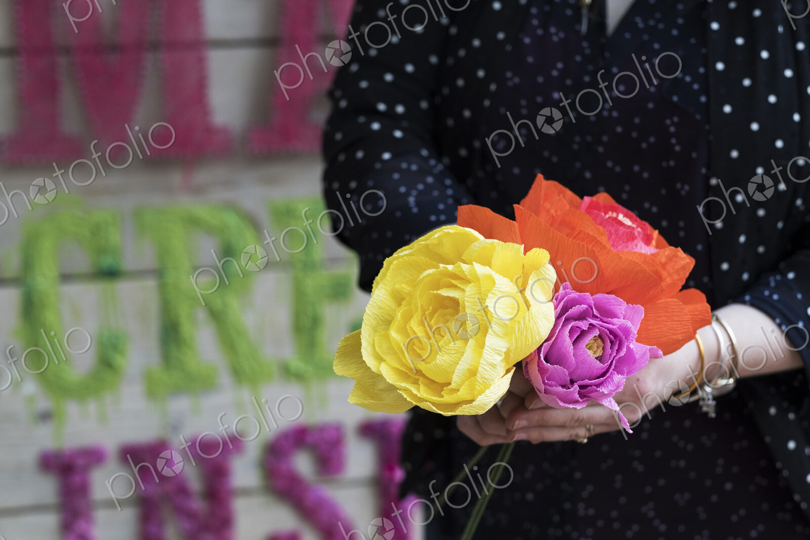 Close up of woman holding handcrafted fabric flowers.