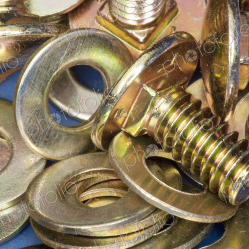 Close-up of yellow metal screws and washers. Close-up of yellow metal screws and washers.