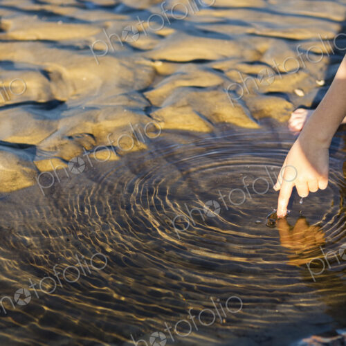 Close up of young boys finger touching water. Close up of young boys finger touching water.