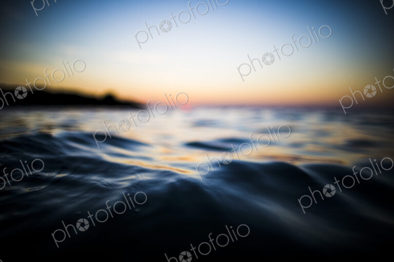 Close up surface view of ocean at sunset.