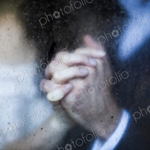 Close up through dirty window of of couple holding hands. Close up through dirty window of of couple holding hands.