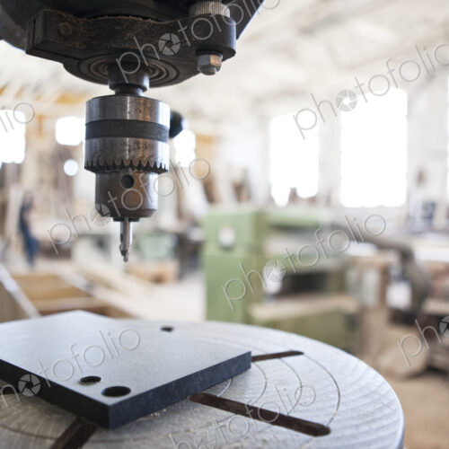 Close up view of a drill press in a woodworking factory.