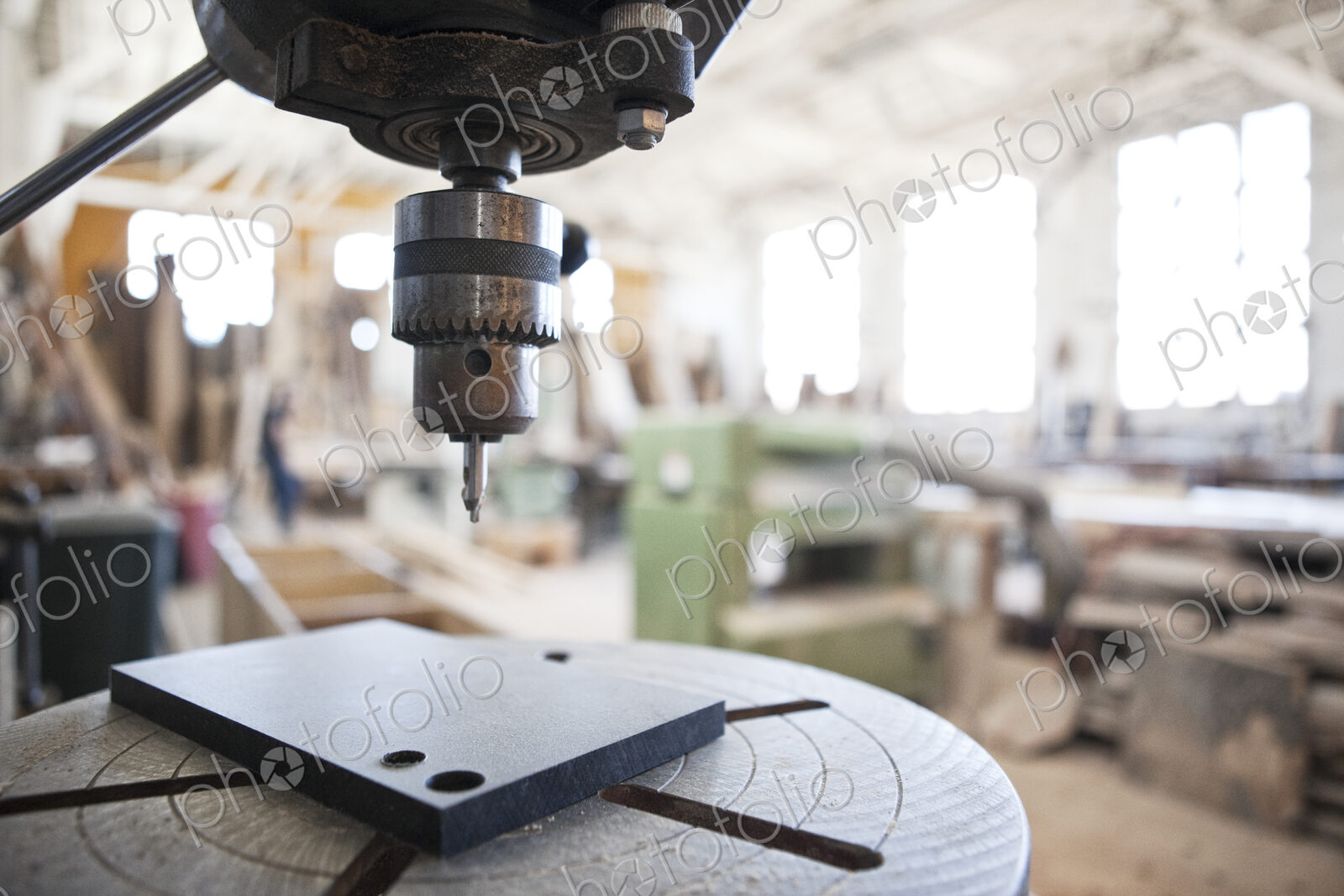 Close up view of a drill press in a woodworking factory.
