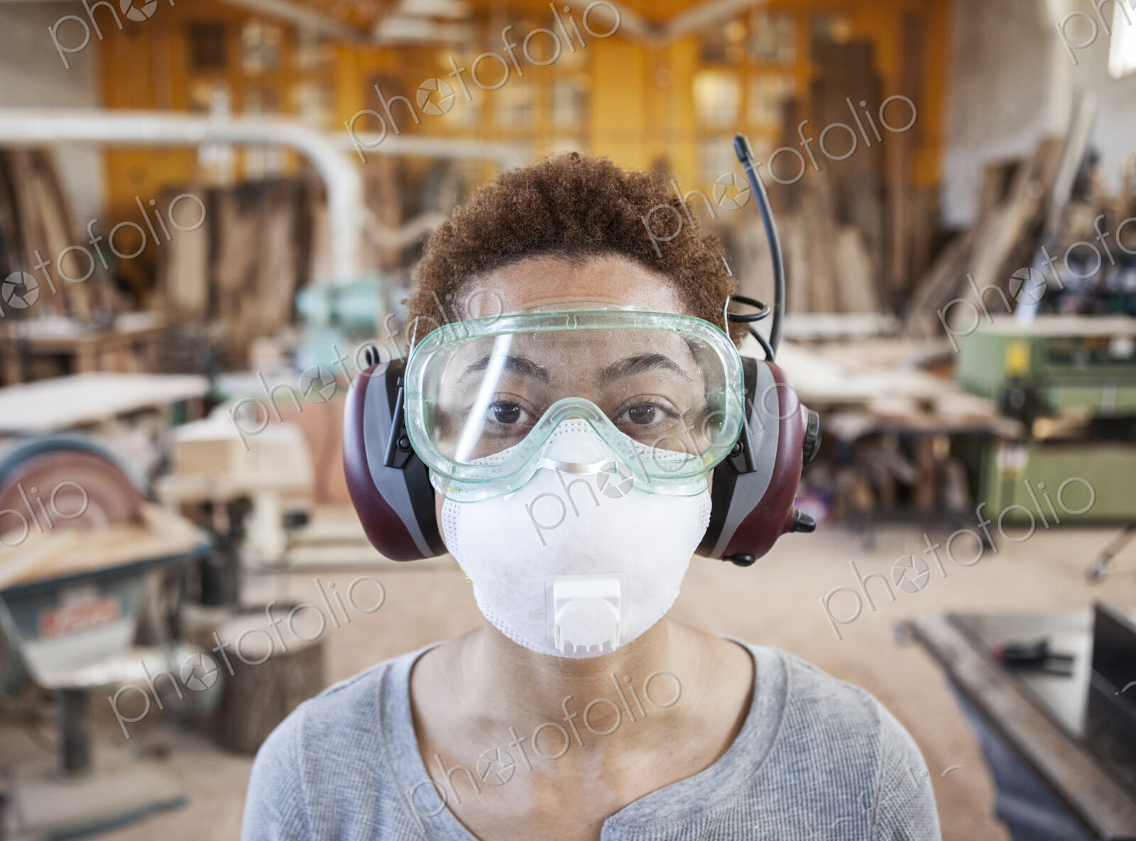 Close up view of black woman factoy worker wearing safety glasses and dust nose mask…