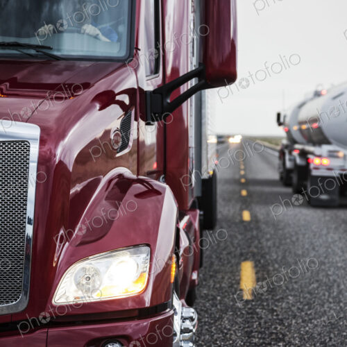 Close up view of the cab and driver of a commercial truck on the highway. Close up view of the cab and driver of a commercial truck on the highway.