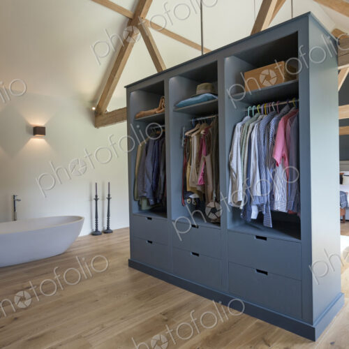 Closet and bathtub in modern bedroom