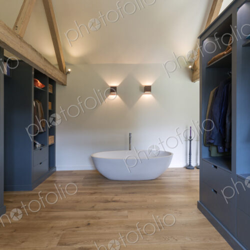 Closet and bathtub in modern bedroom
