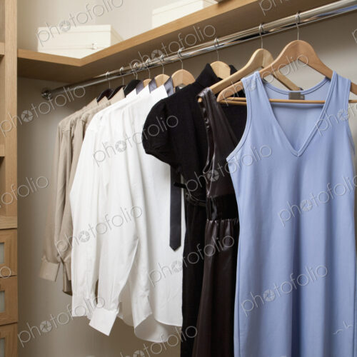 Closet with women's clothes hanging on hangers