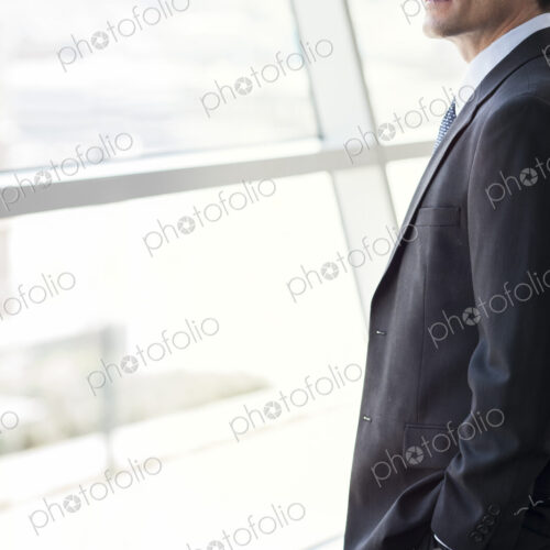 Closeup of a Caucasian businessman looking out the widow of a conference centre lobby.