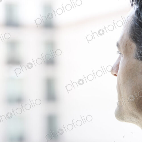 Closeup of a Caucasian businessman lookng out the widow of a conference centre lobby. Closeup of a Caucasian businessman lookng out the widow of a conference centre lobby.