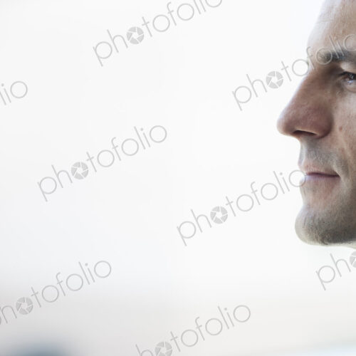 Closeup of a Caucasian businessman lookng out the widow of a conference centre lobby. Closeup of a Caucasian businessman lookng out the widow of a conference centre lobby.