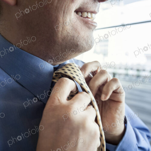 Closeup of a businessman tying his business tie. Closeup of a businessman tying his business tie.