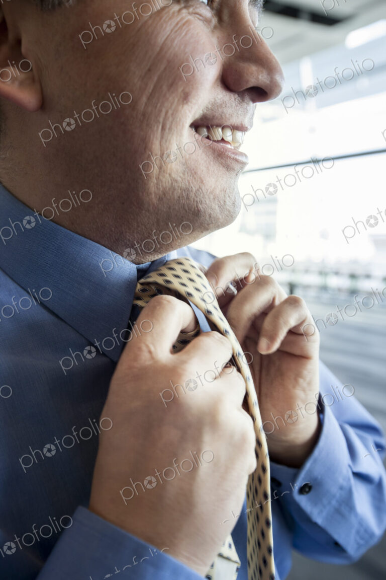 Closeup of a businessman tying his business tie.