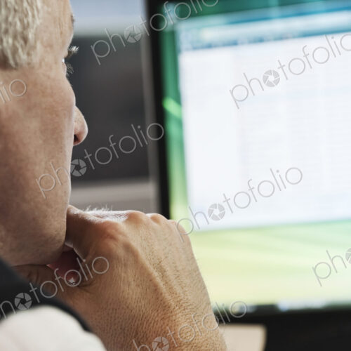 Closeup of a caucasian businessman working on a desktop computer. Closeup of a caucasian businessman working on a desktop computer.