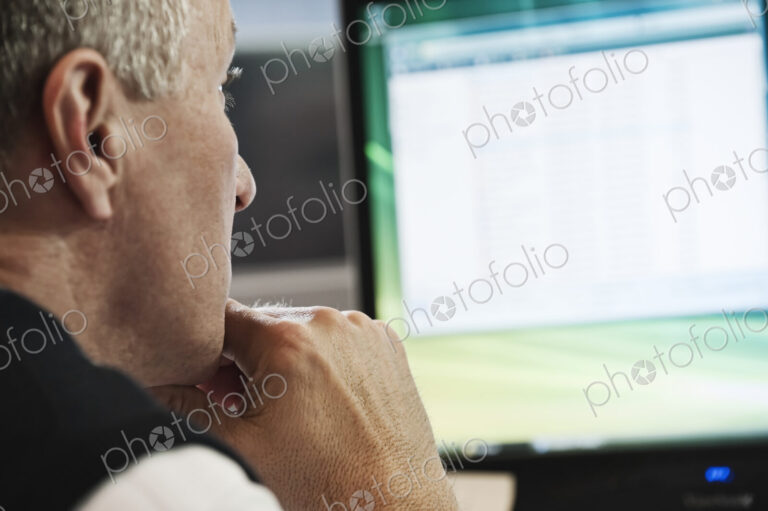 Closeup of a caucasian businessman working on a desktop computer.