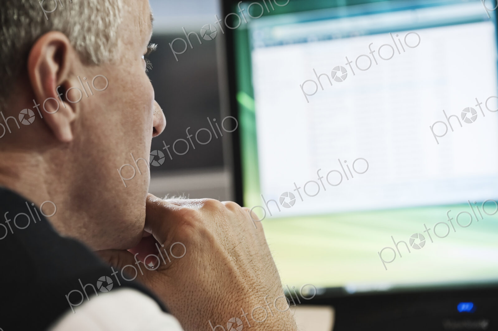 Closeup of a caucasian businessman working on a desktop computer.