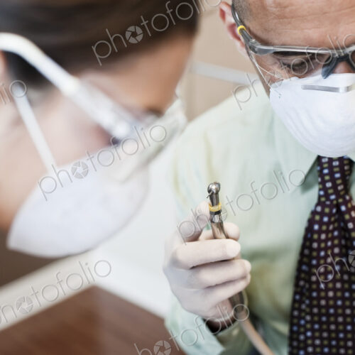 Closeup of a dentist and his assistant working on a patient in a dental office. Closeup of a dentist and his assistant working on a patient in a dental office.
