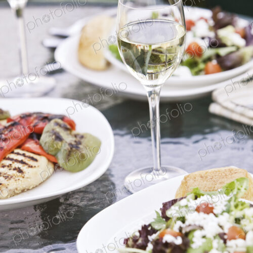 Closeup of a glass of wine and a healthy meal of salad on a table. Closeup of a glass of wine and a healthy meal of salad on a table.