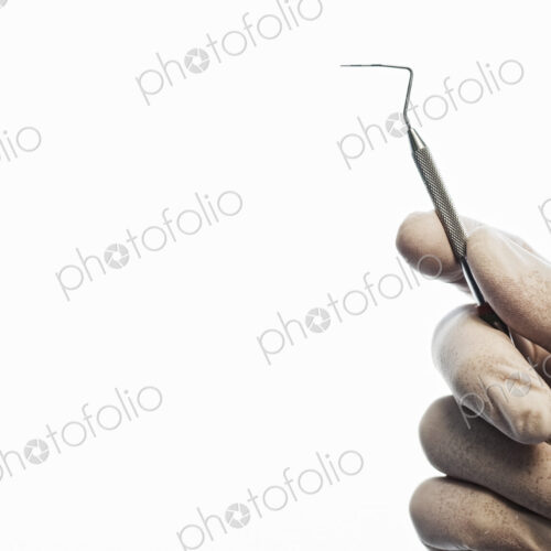 Closeup of a hand holding a dental probe. Closeup of a hand holding a dental probe.