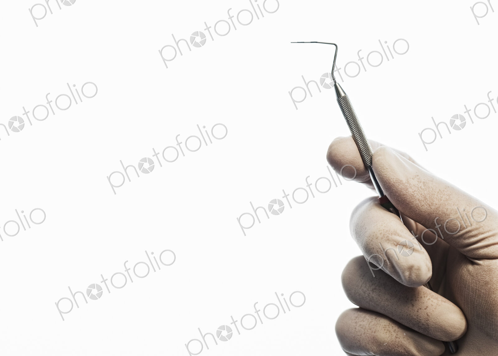 Closeup of a hand holding a dental probe.