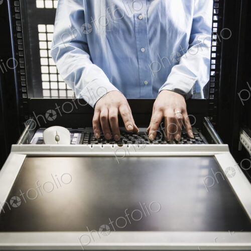 Closeup of a the hands of a technician working on data from a computer server farm. Closeup of a the hands of a technician working on data from a computer server farm.