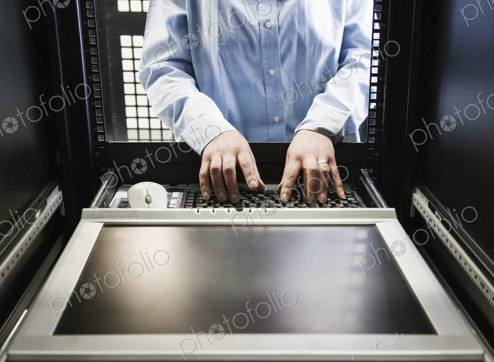 Closeup of a the hands of a technician working on data from a computer server farm.