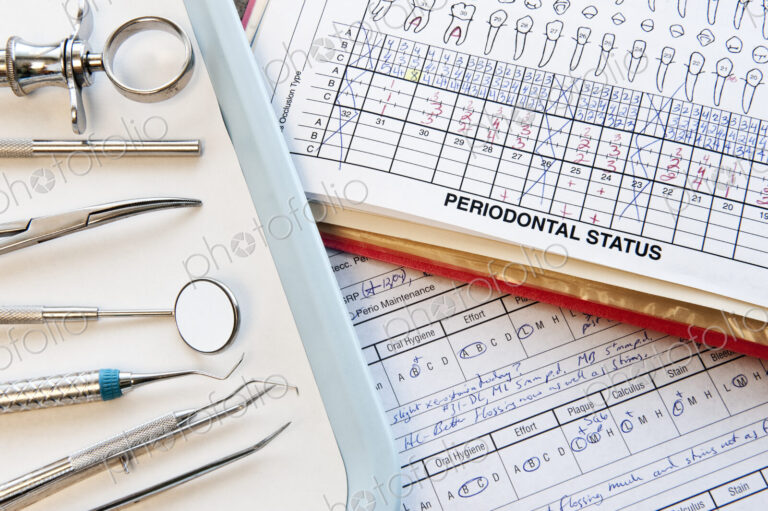 Closeup of dental tools and dental records in a dental office.