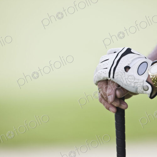 Closeup of hands and golf club.
