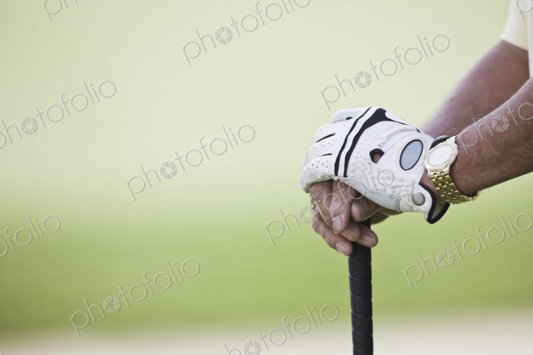 Closeup of hands and golf club.