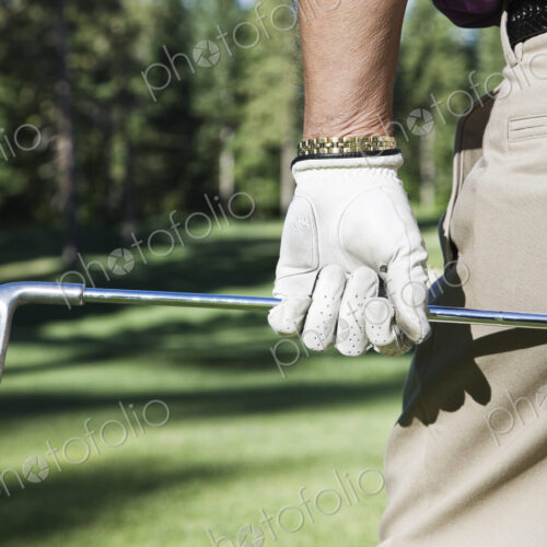 Closeup of hands and golf club.