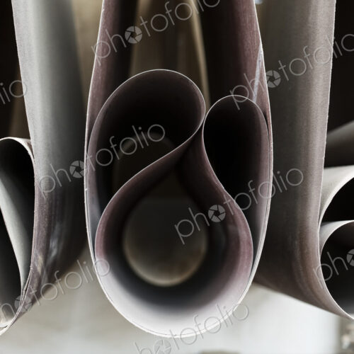 Closeup of sanding belts ready to be used in a wood working shop. Closeup of sanding belts ready to be used in a wood working shop.