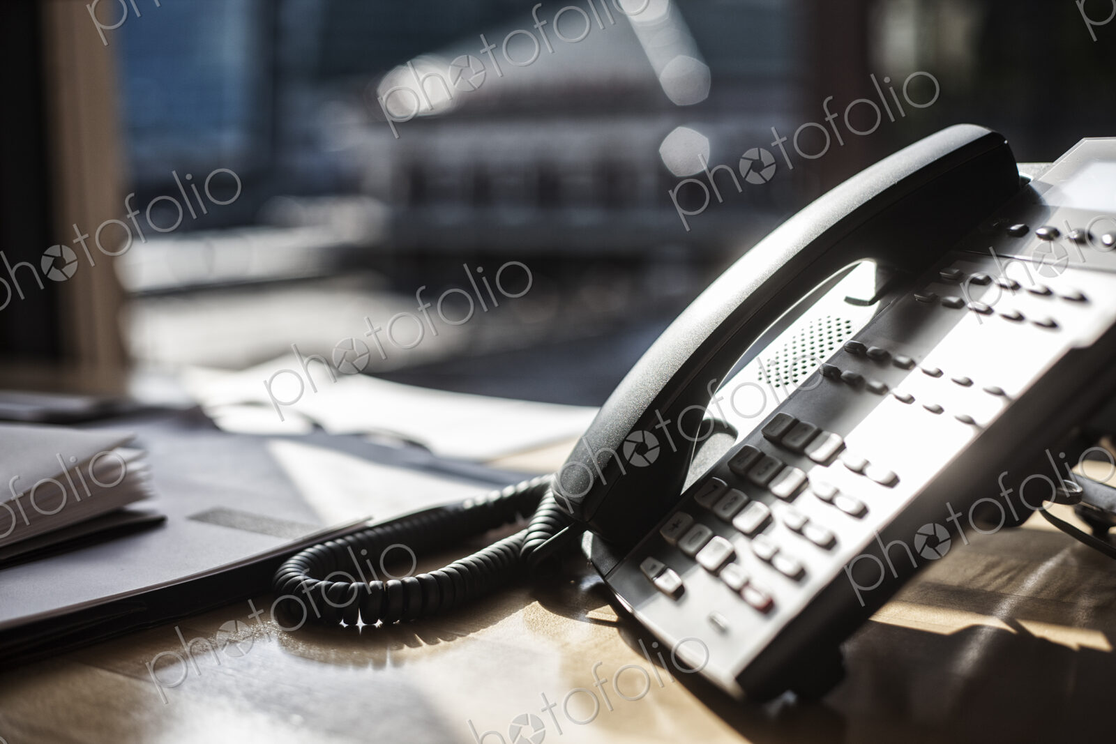 Closeup of telphone and desktop in an office.