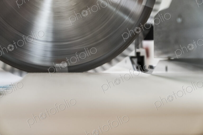 Closeup of the blade on a radial saw in a woodworking factory.