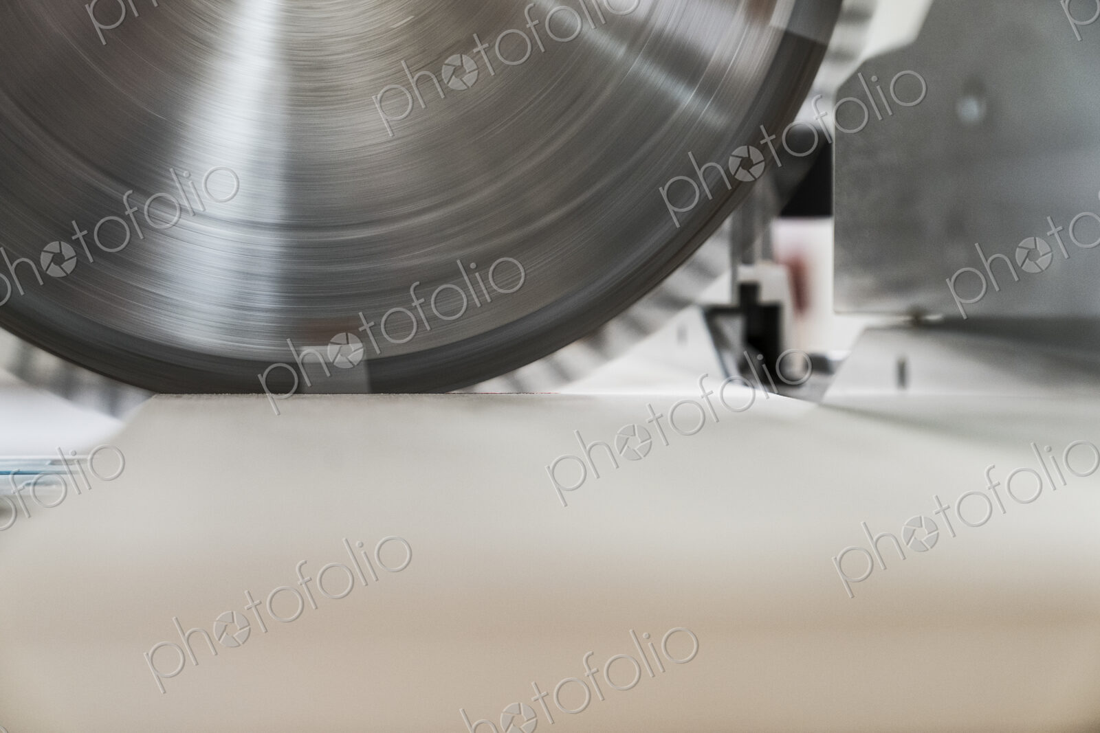 Closeup of the blade on a radial saw in a woodworking factory.