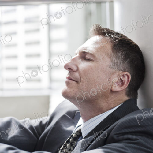 Closeup side view of a caucasian businessman with his eyes closed.. Closeup side view of a caucasian businessman with his eyes closed..