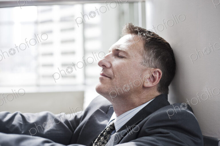Closeup side view of a caucasian businessman with his eyes closed..